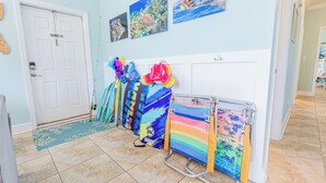 A hallway with a tiled floor, a white door with a 'No Smoking' sign, and a metal rack holding colorful surfboards. - *NEW!*Life is a Marathon~VIEWS!~Pool~Dock~HotTub! (Marathon)