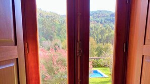 A view through an open door with a pool visible in the background. - MyStay - Casa Guito Rural House (Cepões)