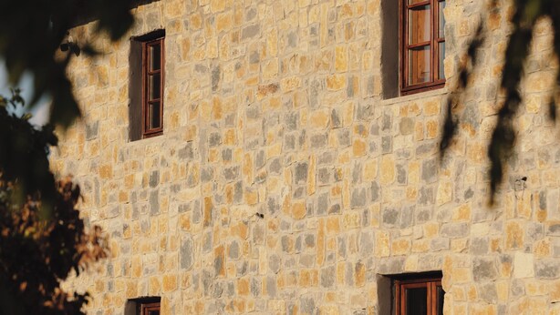 A stone building with three windows, a tiled roof, and a tree in the foreground. - The Podere Wine Resort Chianti (Barberino Tavarnelle)