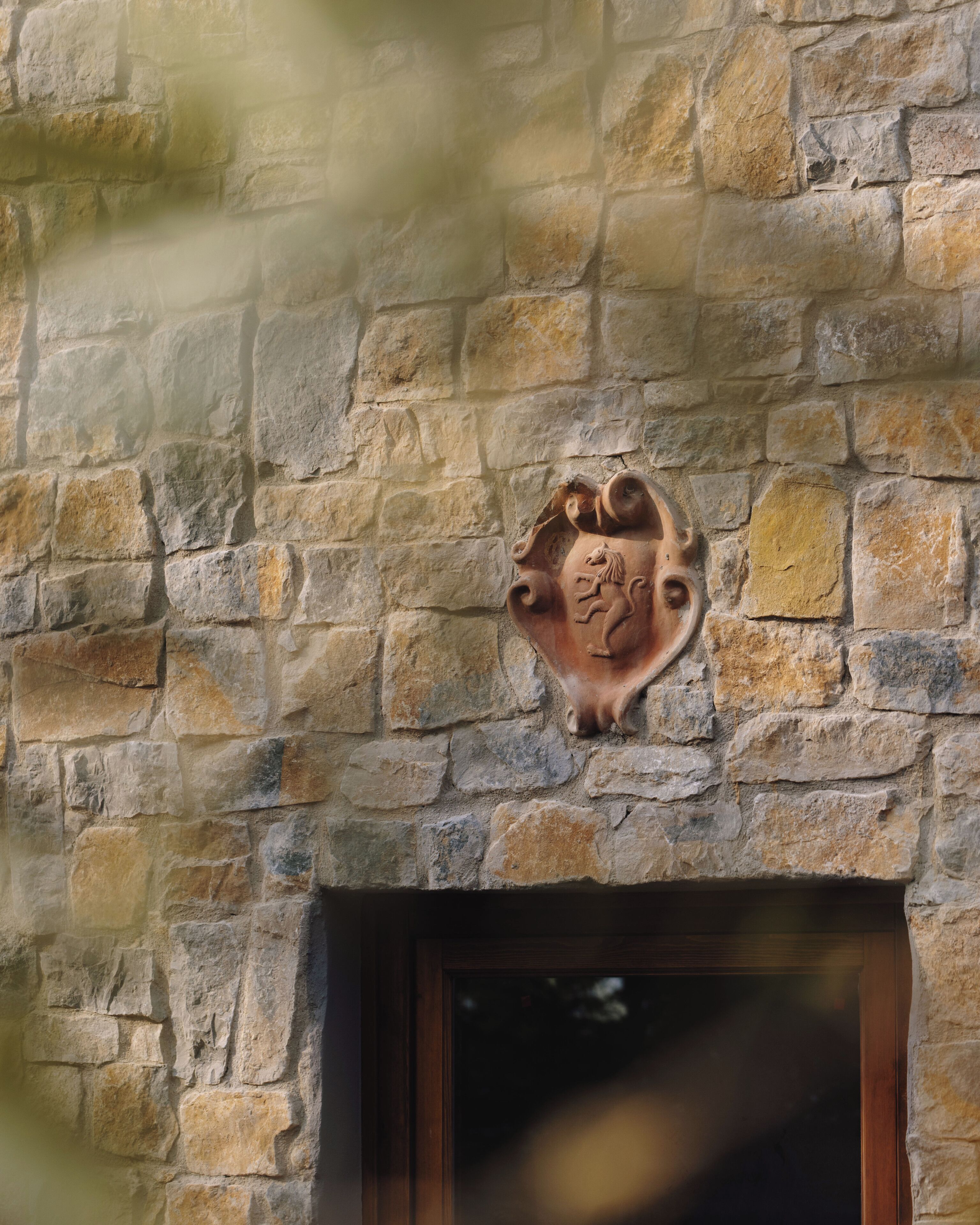 A stone wall with a coat of arms emblem.