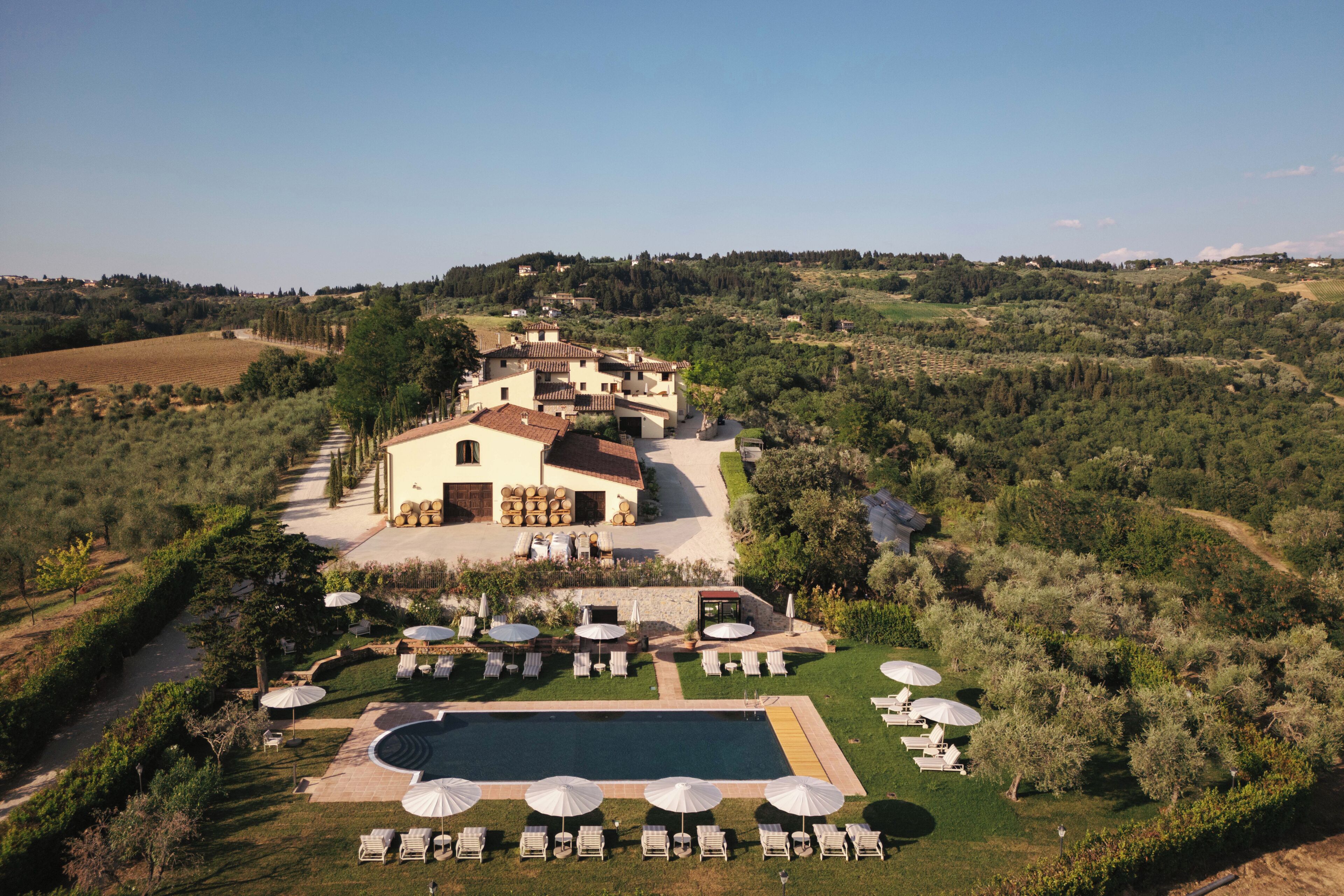 A villa with a swimming pool and outdoor seating area surrounded by greenery.