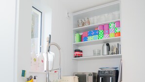 Eine kleine Küche mit einer Mikrowelle, einem Toaster und einem Regal mit bunten Behältern.