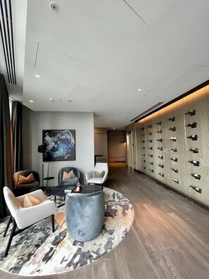 A modern hotel lobby with a seating area, a large wall-mounted wine rack, and a contemporary art piece. - 2 Bed, 2 Bath-Apartment. West Side Place - Central (Melbourne)