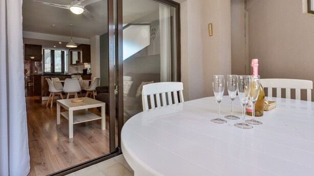A dining area with a white table set for two, two wine glasses, and a bottle of champagne. - Paraiso Mar Apartments in Calpe VICTORIA (Calpe / Calp)
