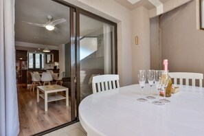 A dining area with a white table set for two, two wine glasses, and a bottle of champagne. - Paraiso Mar Apartments in Calpe VICTORIA (Calpe / Calp)