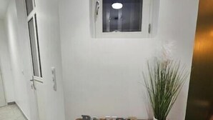 Un tavolo consolle in legno con una pianta in vaso e lettere decorative in un corridoio.