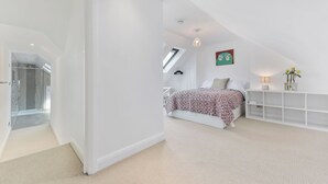A modern bedroom with a bed, a nightstand, a lamp, and a wall-mounted shelf. - Spacious 3BDR On The Southbank With Balcony (Greater London)