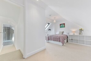 A modern bedroom with a bed, a nightstand, a lamp, and a wall-mounted shelf. - Spacious 3BDR On The Southbank With Balcony (Greater London)
