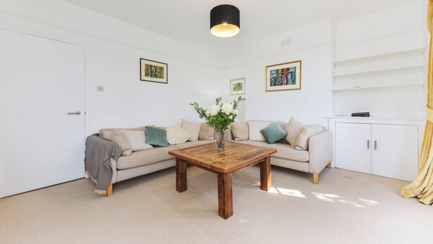 A modern living room with a beige sofa, a wooden coffee table, and a white cabinet. - Spacious 3BDR On The Southbank With Balcony (Greater London)