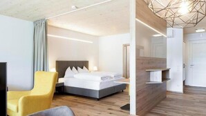 Una camera d'albergo moderna con un letto, una scrivania e una sedia.