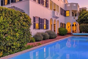 A building with a swimming pool, arched windows, and a well-maintained hedge. - The Walden Suites (Cape Town)