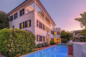 A two-story building with a swimming pool and a well-maintained garden. - The Walden Suites (Cape Town)