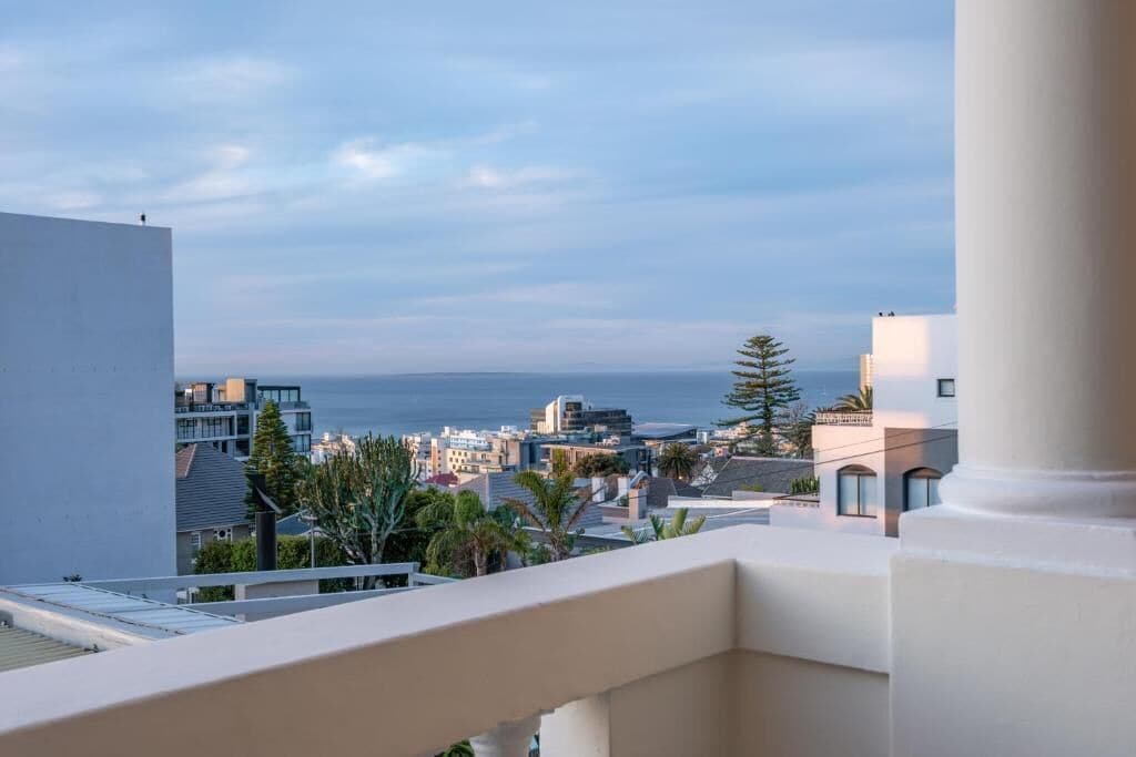 Uma varanda com vista para o mar e a paisagem urbana.
