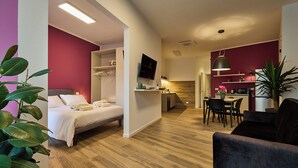 A modern hotel room with a bed, a dining area, and a kitchen. - Suite In Town Home (Bologna)