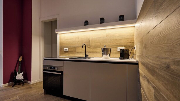 A modern kitchen with a built-in oven, a sink, and a coffee machine. - Suite In Town Home (Bologna)
