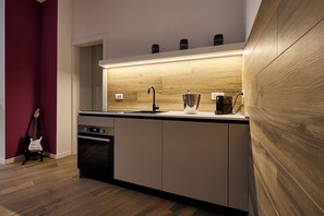 A modern kitchen with a built-in oven, a sink, and a coffee machine. - Suite In Town Home (Bologna)