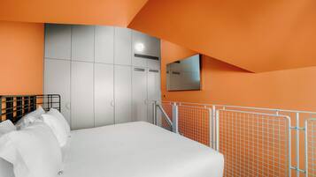 Une chambre à coucher avec un lit, une armoire, un miroir et une rambarde.