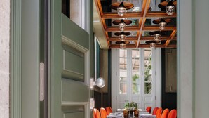 A dining area with a long table, multiple chairs, and a patterned floor. - Axis Avenida (Viana do Castelo)