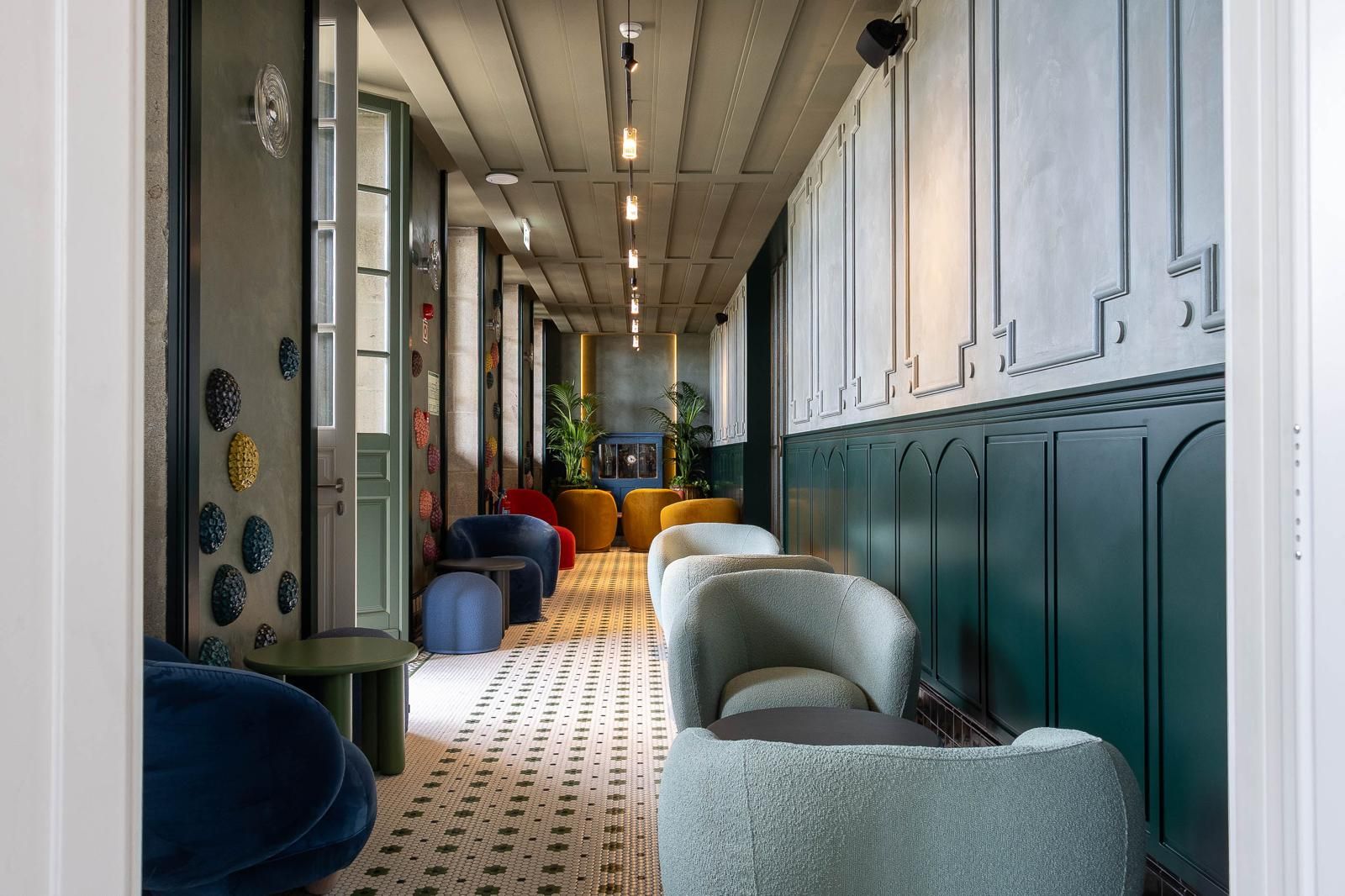 Un pasillo con zonas de estar, piso estampado y una pared con detalles decorativos.