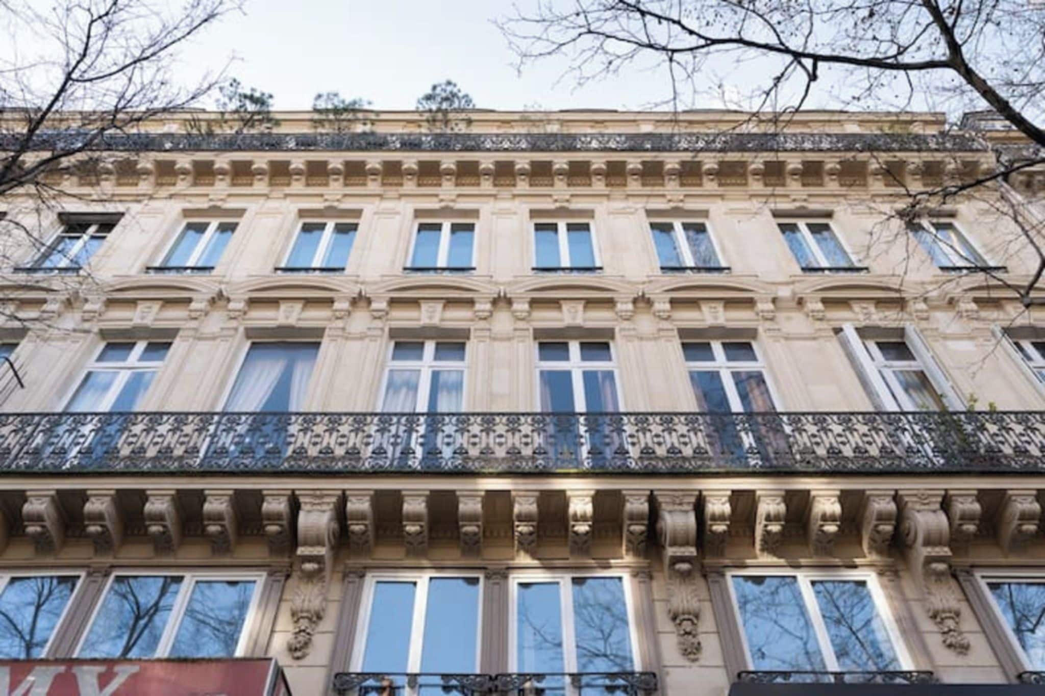 Ein mehrstöckiges Gebäude im klassischen Stil mit einem Balkon und aufwendigen Brüstungen.