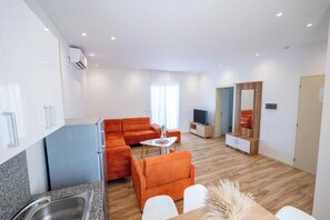 Una sala de estar moderna con un sofá, una mesa de centro y un televisor.