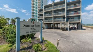 A multi-story hotel named 'Summer House West' with a sign indicating its address.