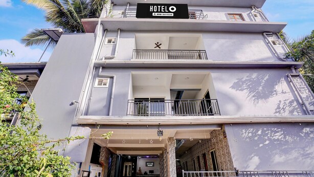A multi-story hotel with a sign reading 'HOTELO' and 'GYD-Service'. - Deluxe Room Ravai (Calangute)