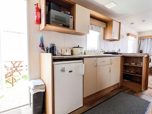 A compact kitchen with a microwave, toaster, and refrigerator. - Pathway to the sea (Prestatyn)