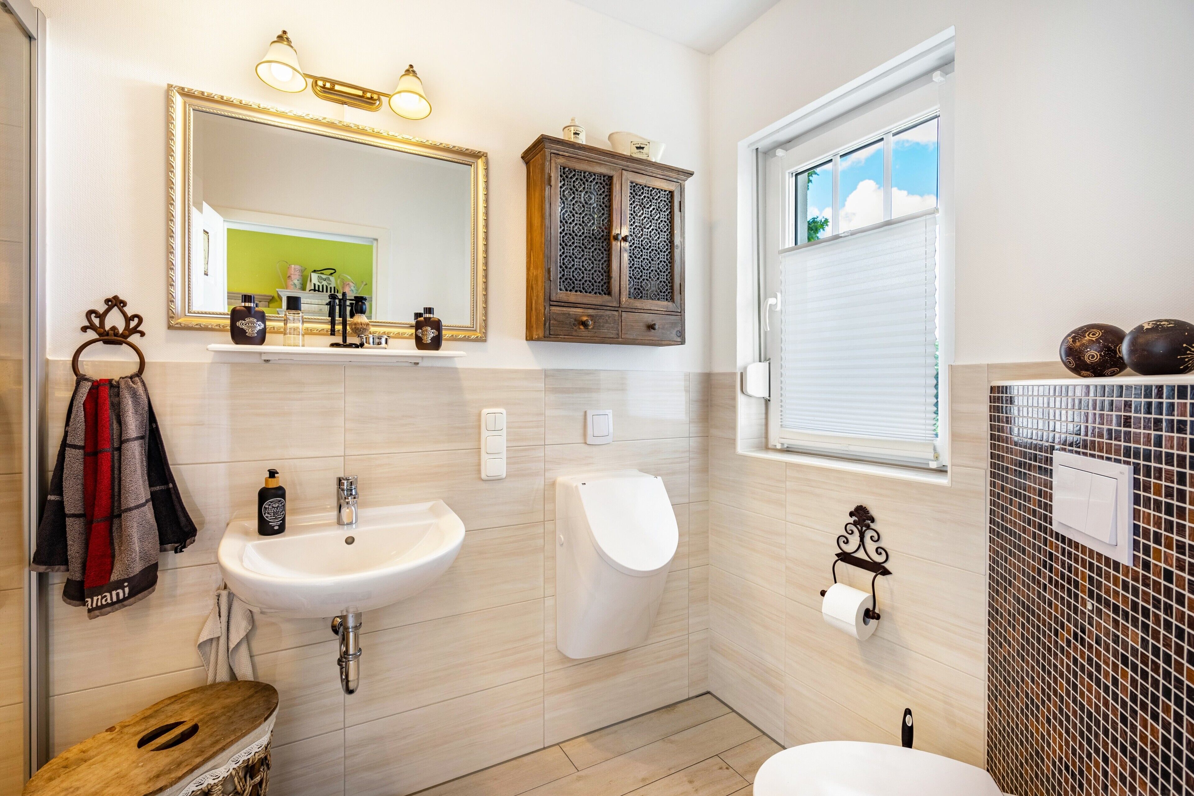 A bathroom with a sink, mirror, vanity, and a window.
