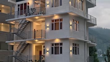 A multi-story building with balconies, staircases, and exterior lighting.