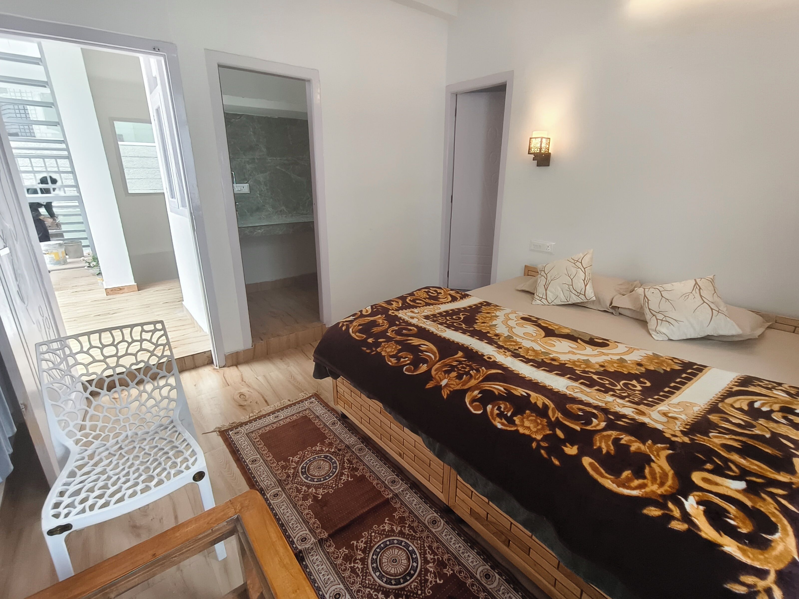 Quarto com cama, uma cadeira e vista para o exterior.