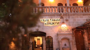 A building with a sign reading 'YILDIZ SARAYI KONUKEVI' and a balcony with railings. - Yıldız Sarayı Butik Otel (Sanliurfa)