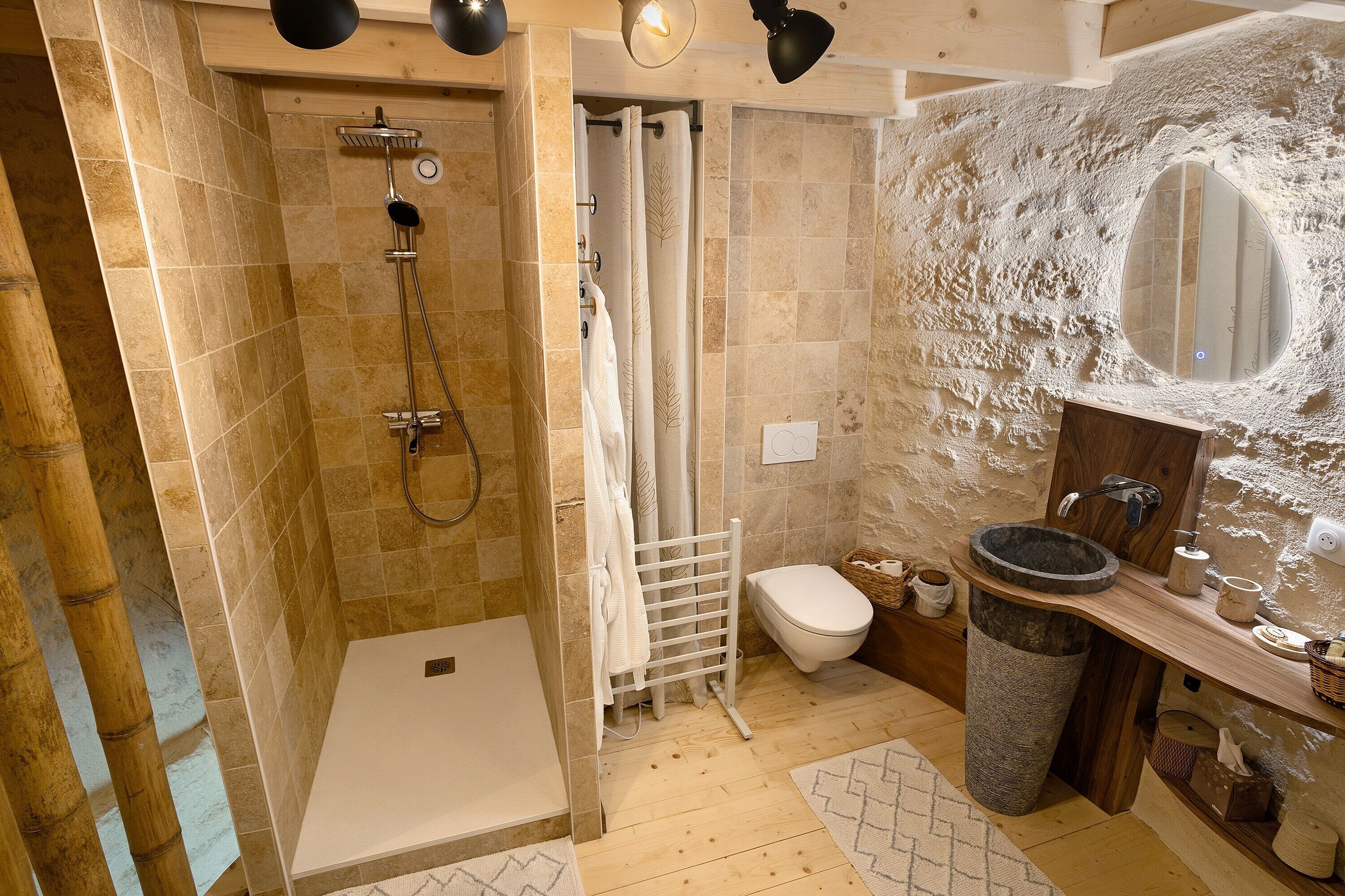Een badkamer met douche, toilet en wastafel.