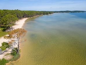 A coastal landscape with a sandy beach, clear water, and dense forest. - Charming house with AC, pets OK - 4 guests (Parentis-en-Born)