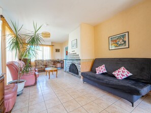 A living room with a sofa, armchairs, a coffee table, a fireplace, and a large potted plant. - House in Mimizan - 6 guests (Mimizan)
