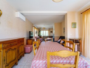 A spacious living room with a long dining table, a television, and a fireplace. - House in Mimizan - 6 guests (Mimizan)