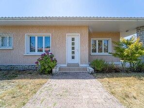 A single-story house with a paved entrance, a front door, and two windows with white frames. - House in Mimizan - 6 guests (Mimizan)