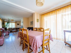 A dining area with a table set for four, surrounded by wooden chairs. - House in Mimizan - 6 guests (Mimizan)