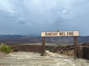 A sign reading 'RANCHO MELING' with a mountainous landscape in the background.