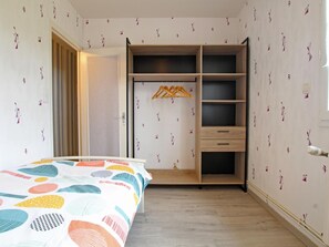 A bedroom with a bed, a wardrobe, and a hanging rack. - Spacious house with parking - 6 guests (Les Loges-Marchis)