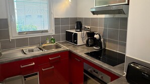 Cocina compacta con microondas, cafetera y tostadora.