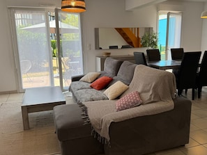 Ein Wohnzimmer mit einer Couch, einem Couchtisch und einem Essbereich mit Stühlen und einem Tisch.