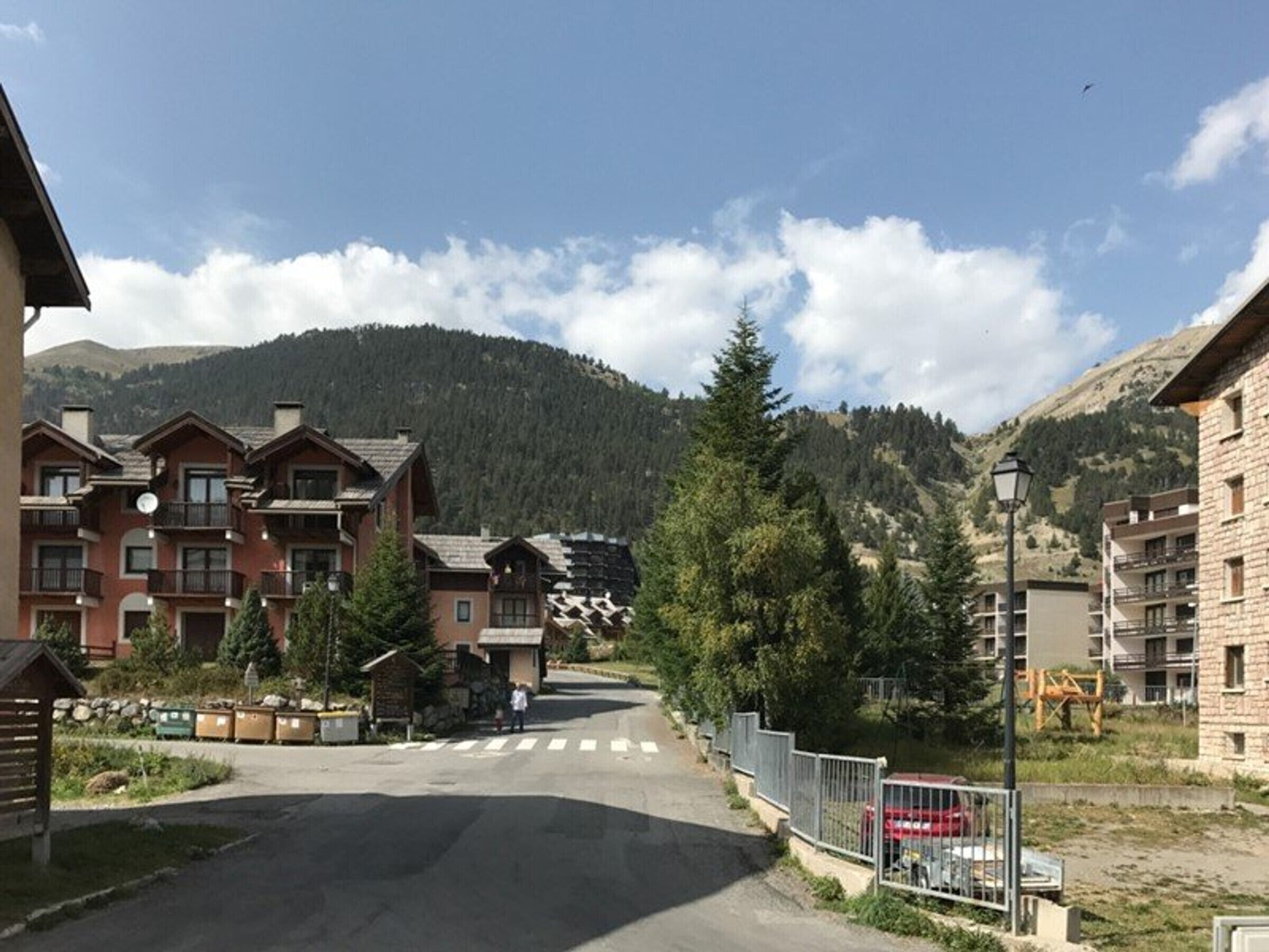 Ein Bergort mit mehrstöckigen Gebäuden, einer Fußgängerampel und freiem Blick auf den umliegenden Wald und die Hügel.