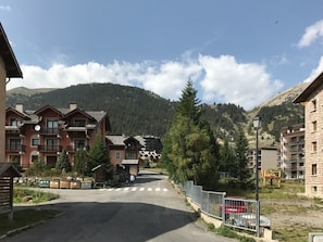 Ein Bergort mit mehrstöckigen Gebäuden, einer Fußgängerampel und freiem Blick auf den umliegenden Wald und die Hügel.