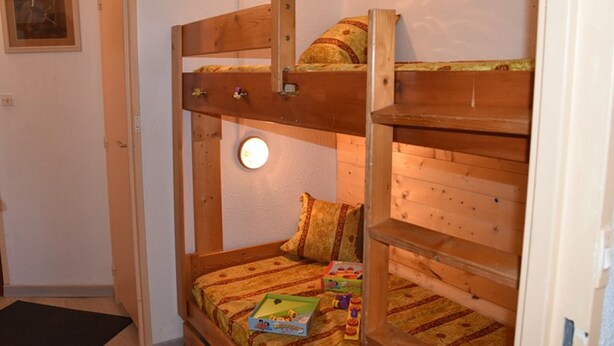 A bunk bed room with a door, a wall-mounted light, and a framed picture. - Apartment with village and slopes view - 6 guests (Montgenèvre)