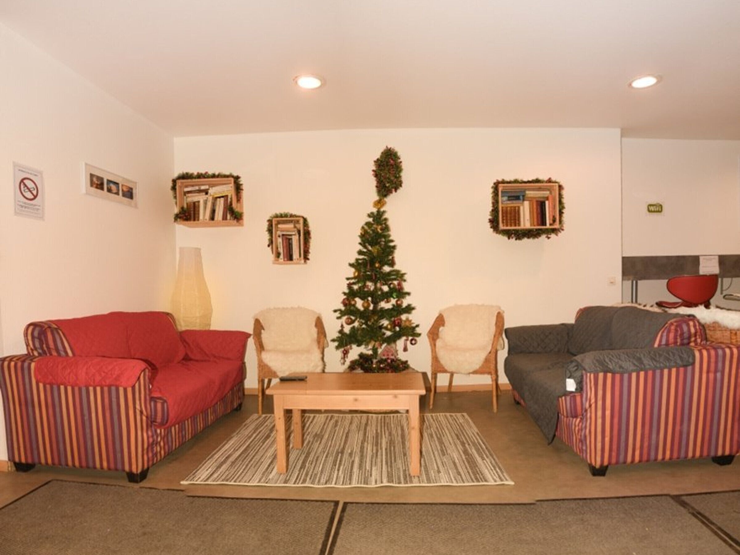 A living room with two sofas, a coffee table, and a Christmas tree.