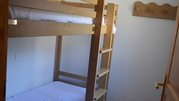 A bunk bed with a wooden ladder and a white mattress. - Cozy studio, mountain view (Montgenèvre)