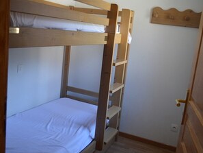 A bunk bed with a wooden ladder and a white mattress. - Cozy studio, mountain view (Montgenèvre)