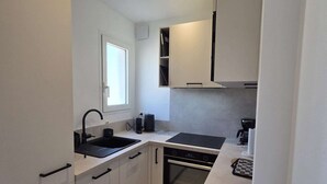 A modern kitchen with a built-in oven, a sink, and a window. - Apartment sea view, AC - 4 guests (Lumio)