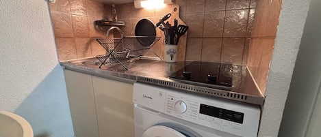 Cocina compacta con lavadora, lavaplatos y un portalapices.